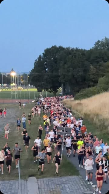 Hunderte Läuferinnen und Läufer bei einem Social Sports Club Run in der Abenddämmerung